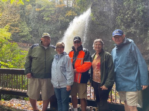 Group standing together with waterfall in the background.